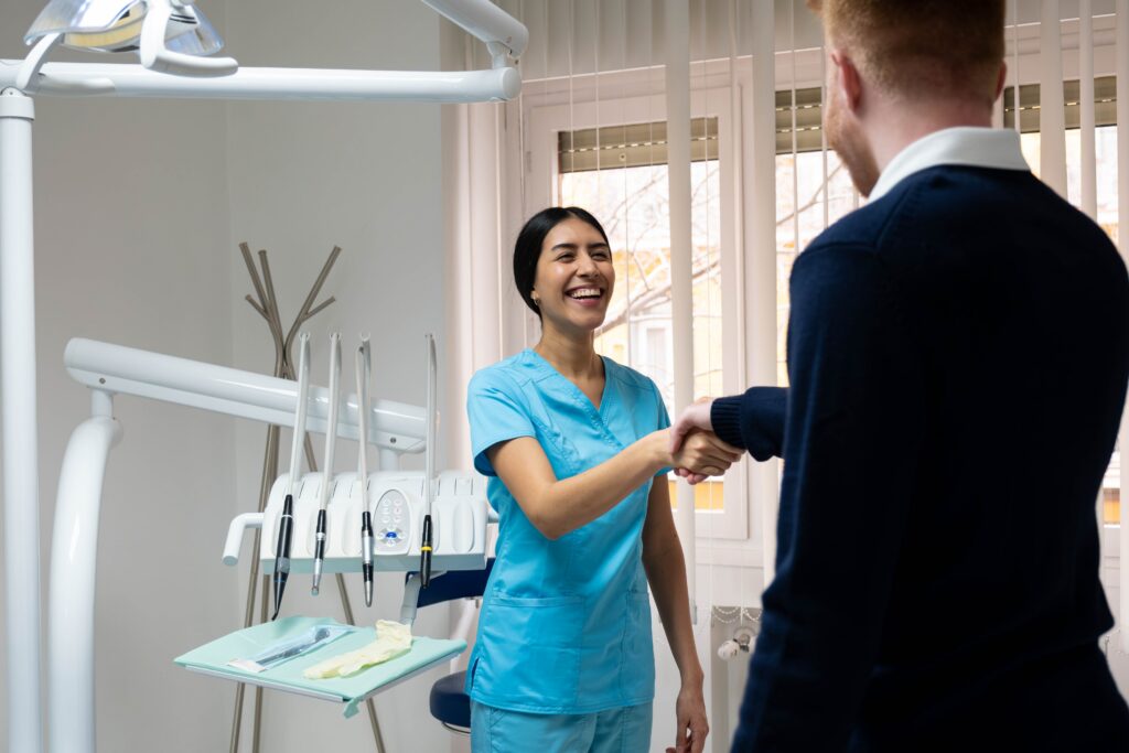 Female dentist shaking hands with a male patient